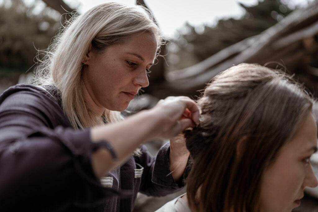 Norma, coiffeuse événementielle, en pleine réalisation d’une coiffure en extérieur lors d’un shooting mode