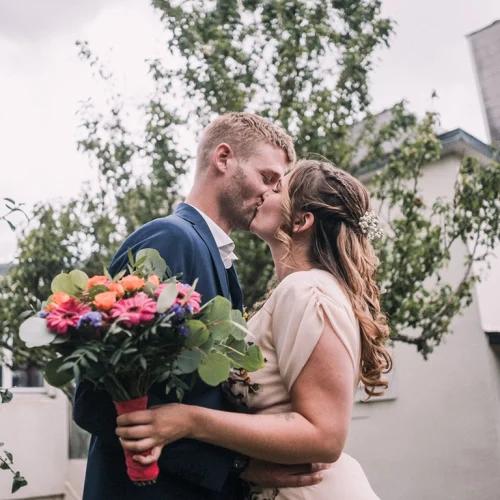 Baiser des mariés à la sortie du Manoir de Kerouzien à Plomelin, coiffure assurée par Norma